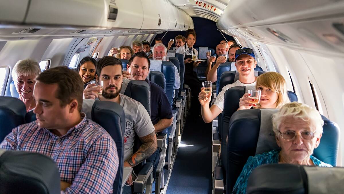 HERE'S CHEERS: Passengers on the first direct flight from Brisbane to Orange celebrate with a glass of champagne on Monday morning. Photo: Supplied Bernard Proctor