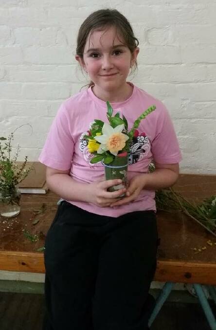 Cailee Anderson shows off a flower arrangement she made at last year's workshop. 