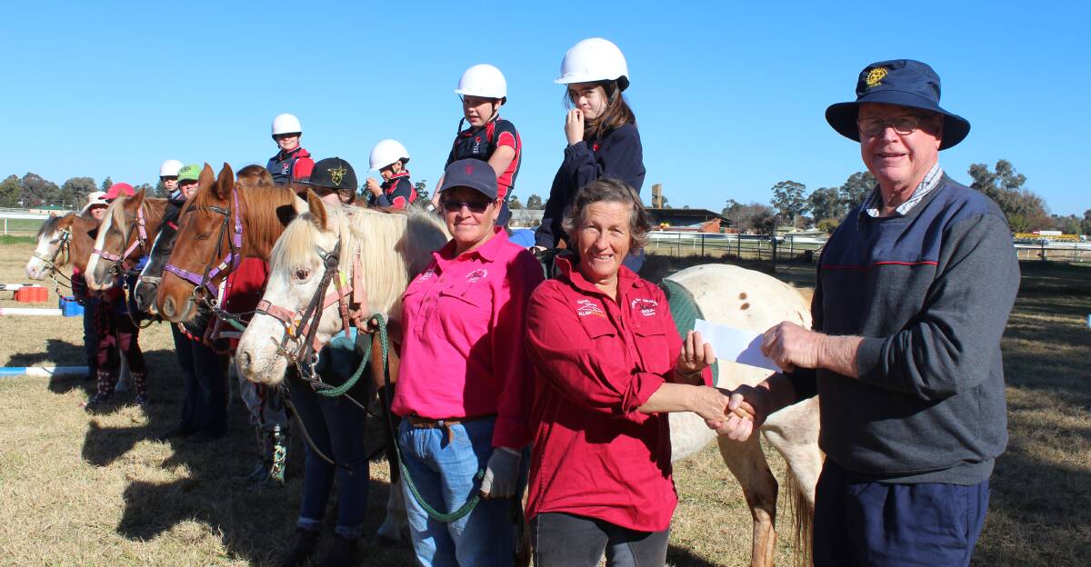 Cowra RDA President Frances Woodbridge with Cowra Rotary Club President Ken Harris and volunteers and clients from Riding for the Disabled. 