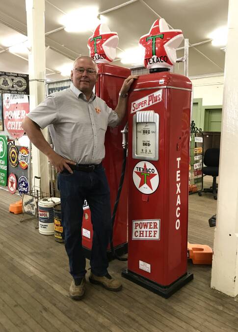  Auctioneer Ashley Burns, next to two Texaco petrol pumps that are part of the auction.