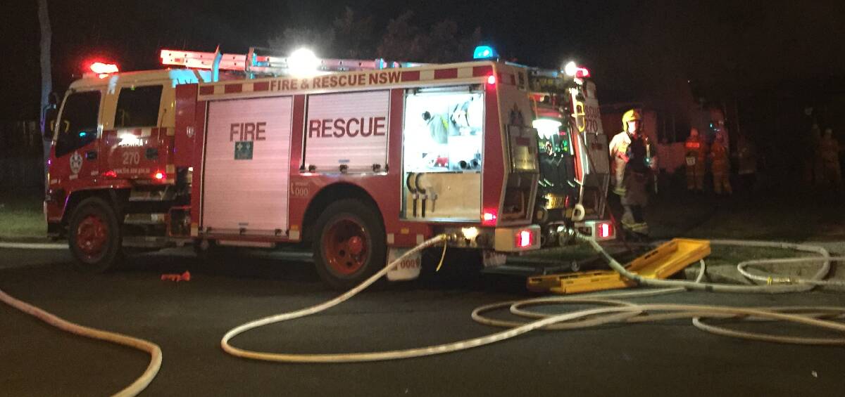 Firefighters attend the scene of a house fire in Cooyal Street, Cowra last Tuesday night. A 99-year-old local woman was rescued by neighbours and did not sustain any injuries. 