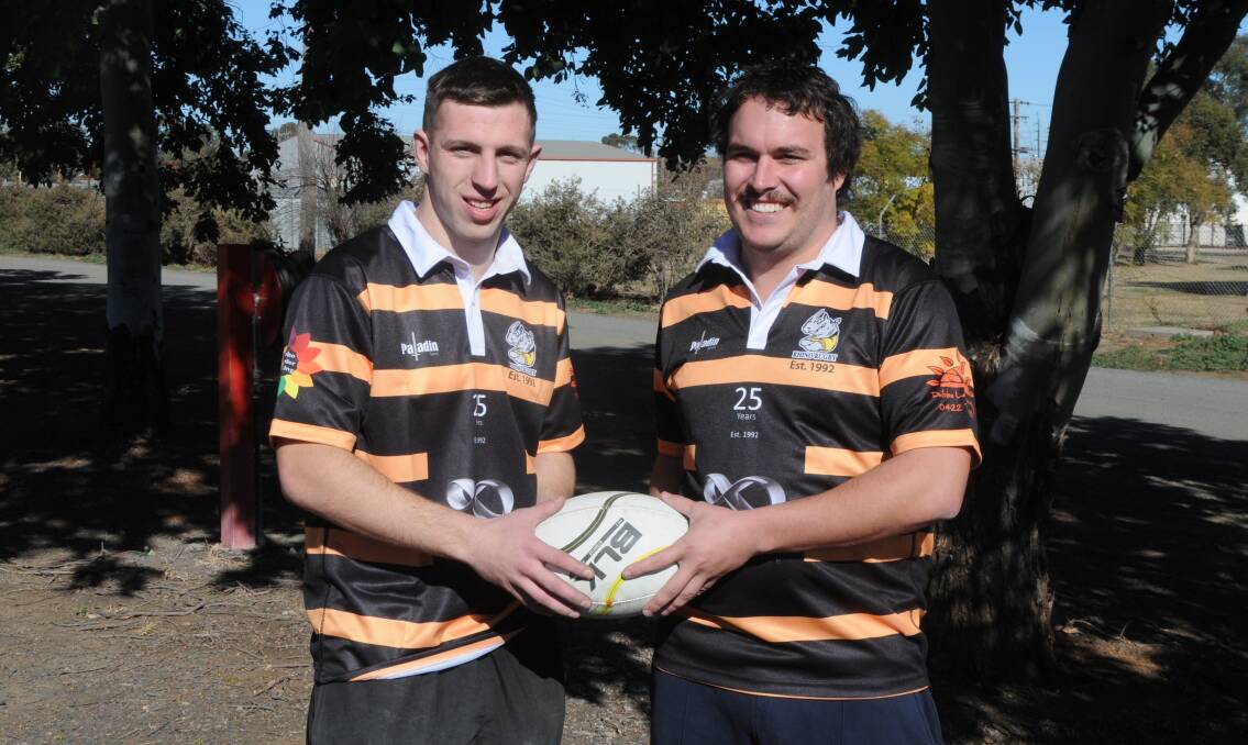 READY TO RUMBLE: Ross Gilmour and Rhinos captain Jordan Davis wearing the 25 year anniversary jerseys to be worn this weekend. Photo: NICK GUTHRIE