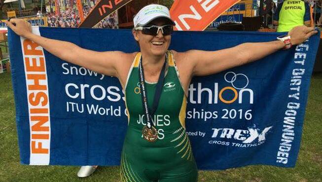 Pictured at the Cross Triathlon finish line, Tabitha Jones celebrates completing the rugged Snowy Mountains course.