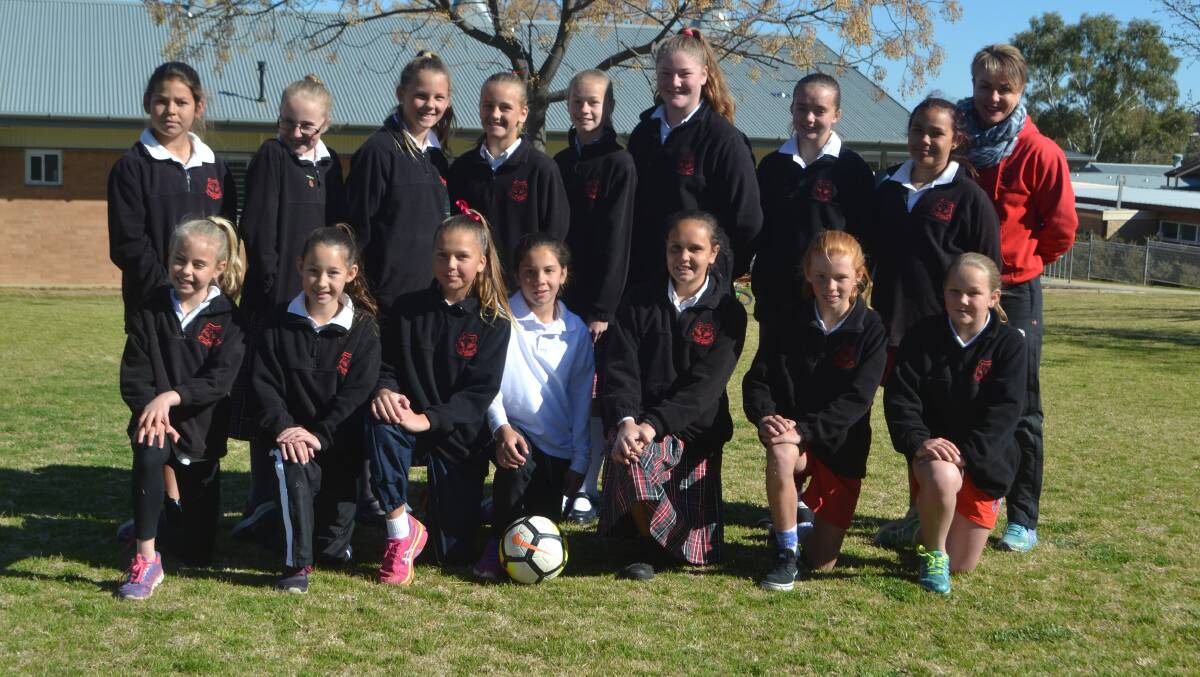 Mulyan Public School's girls soccer side smiles for a team photo after qualifying for the NSW PSSA quarter finals.