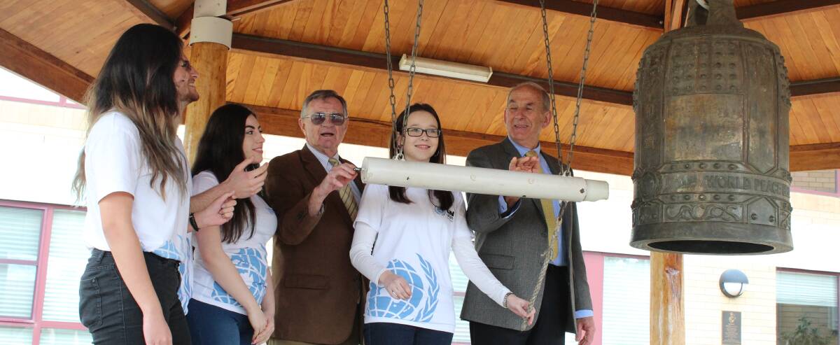 Ringing the bell: United Nations Youth Australia guests Akile Numan, Karen Du, Zoe Stwyskyj and Matt Friedman ring the Cowra Peace Bell with Ian Brown and Councillor Bill West.