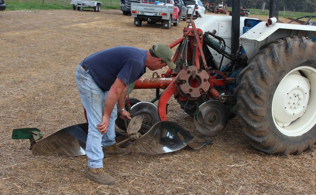 Shaun Carson makes a few adjustments to his plough.