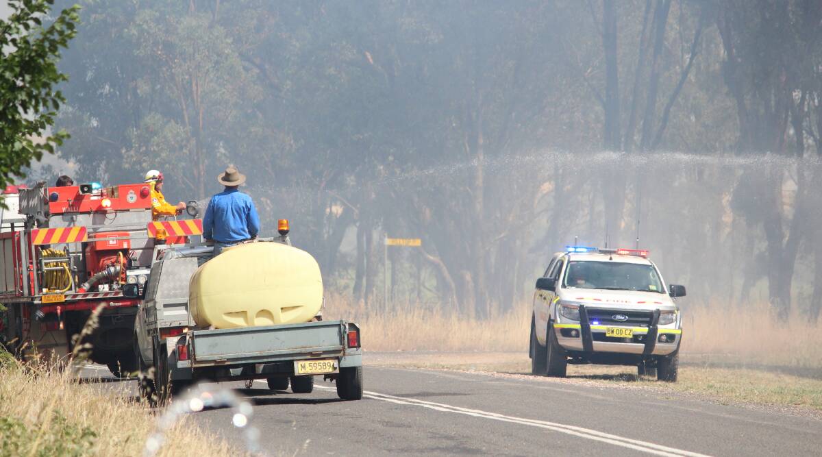 Emergency crews at the site of the Woodstock grass fire last December. A campaign has been launched for a 40km/h speed limit at emergency scenes as a safety measure.