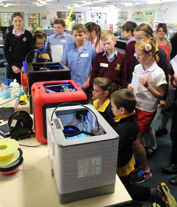 Students from Cowra and Cabonne schools look on as their projects begin printing during the 3D printing workshop at Cowra Public School.
