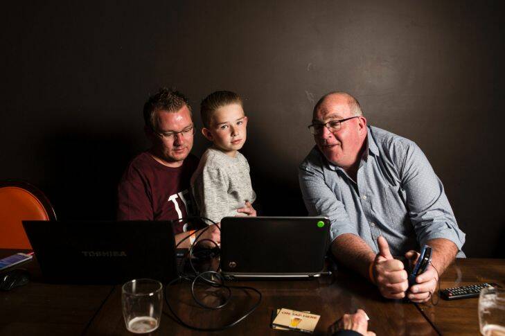 The Queanbeyan-Palerang election.
Kenrick Winchester, his nephew Riley Element 10, and Tony Woods check election results as they roll in.
Photo: Jamila Toderas