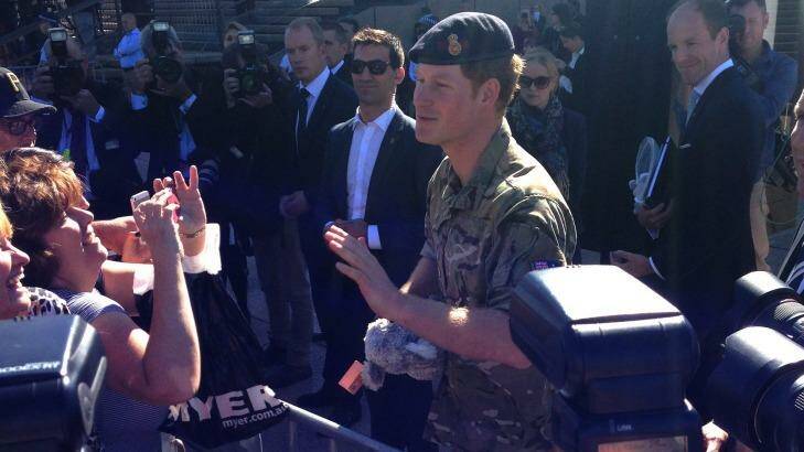 Prince Harry, dressed in his combat fatigues, greets fans at the Sydney Opera House. Photo: Jenna Clarke