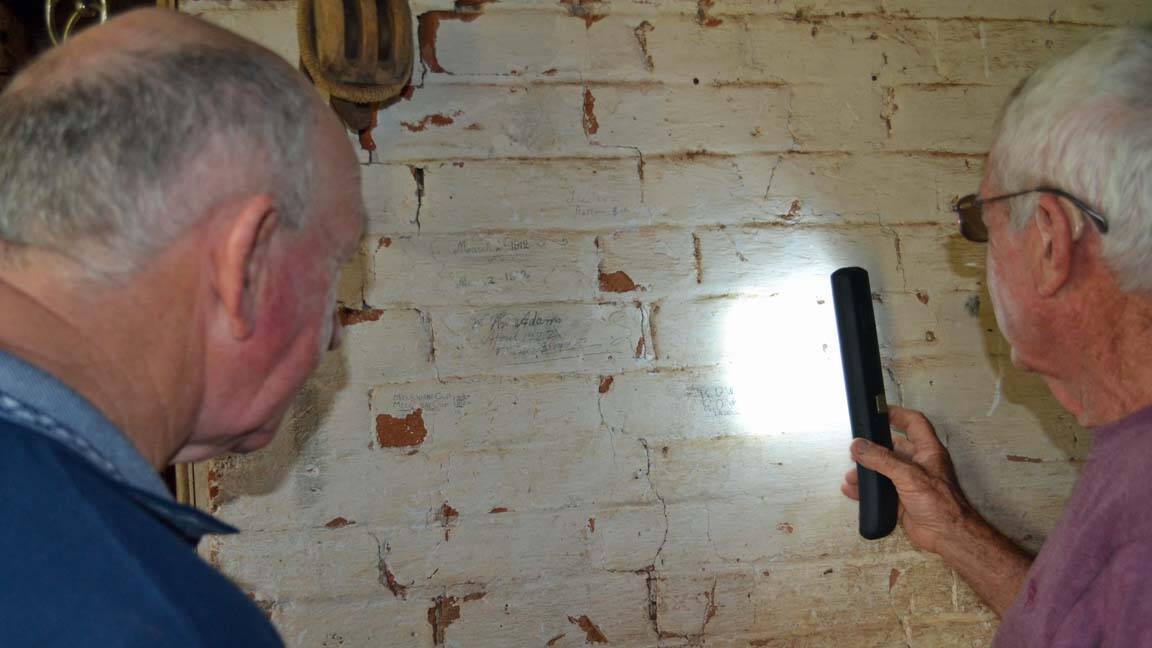 Ray Walsh and Noel Honeybrook inspect some historical writing on the stable walls. 