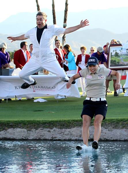 Major winning jump: Adam Woodward and Sun Young Yoo make the traditional leap into the pond. Photo by Stephen Dunn/Getty Images.
