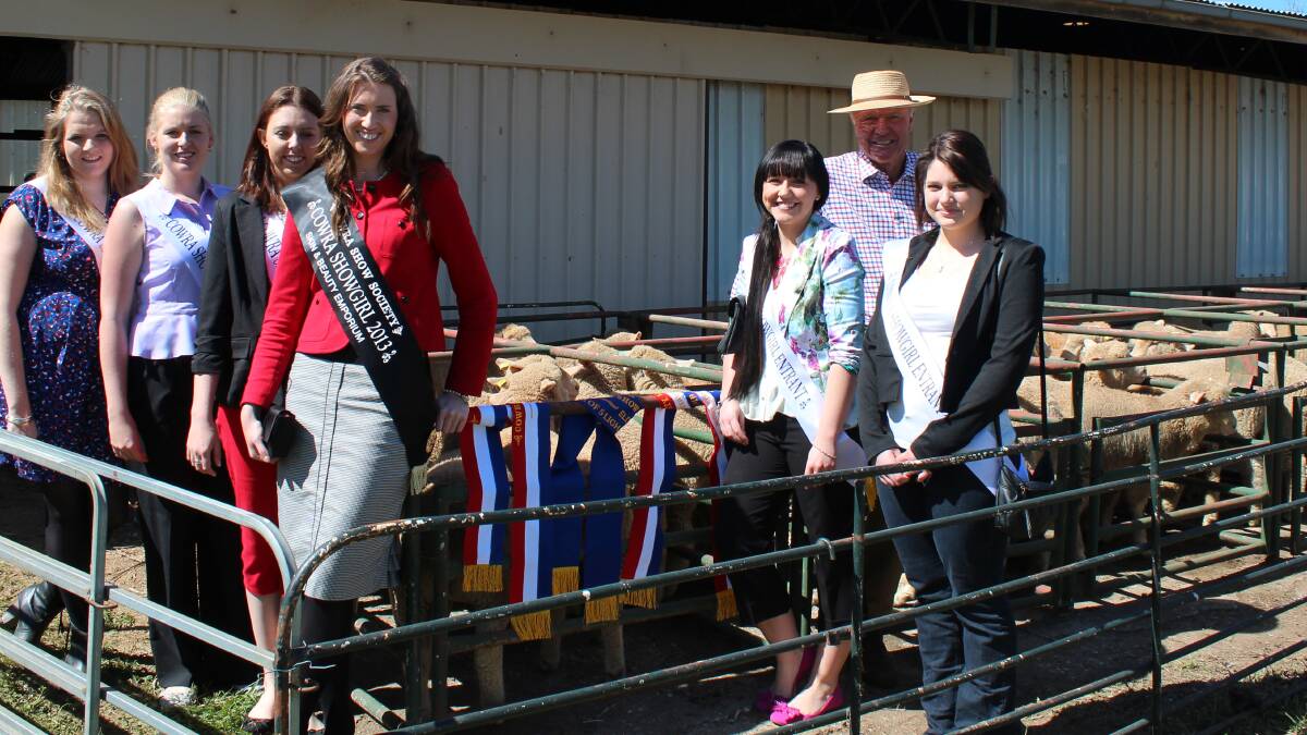 Cowra Showgirls and Ian Dodges in front of the champion Prime Lamb pen.