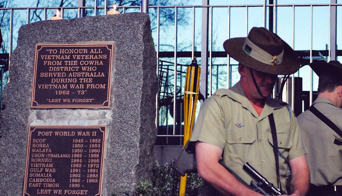 Candles burning atop the cenotaph….Army Reserve officer Craig Simpson, member of the catafalque party during a past Vietnam Veterans service in Cowra.