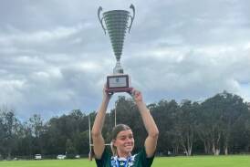 Emilie Browne holding the grand final trophy secured by the Western Rams
