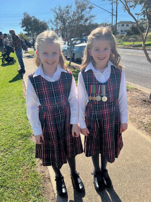 Twins Isla and Allie Sutherland wearing their Great Grandfather's service medals from WWII (supplied)