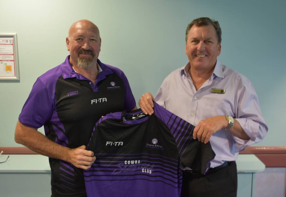 Cowra Country Over 35s organiser Steve Ford with Lloyd Garratt, general manager of the tournament's major sponsor, the Cowra Services Club, holding the Cowra playing guernsey. Photo: Ben Rodin