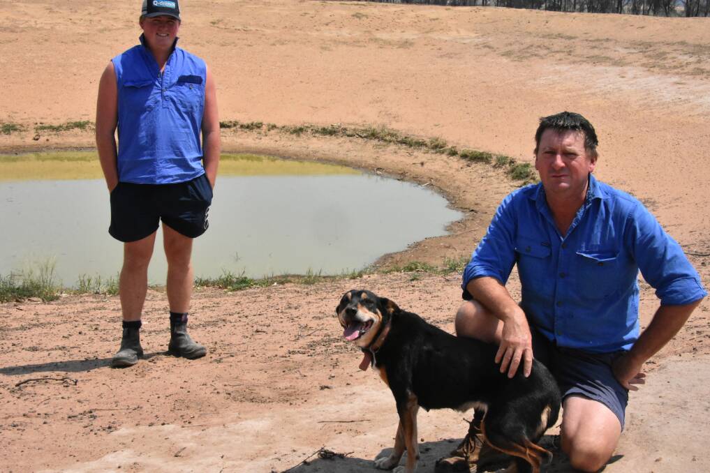NSW Farmers Association vice president Chris Grove and his son Oliver inspecting one of the last dams's on their Cowra property holding water.