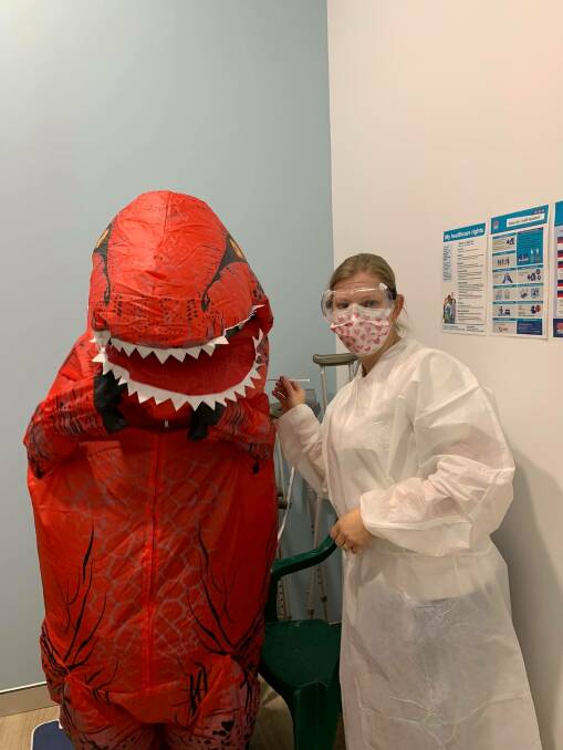 Optimal Pharmacist Susie Nash vaccinating Cowra's "Tee-Rex" against COVID-19 at the pharmacy last week.