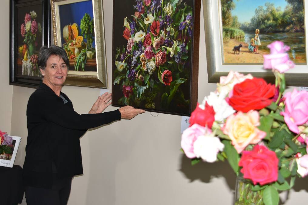 Tourism officer Jenny Wright with some of the works in the Ann Morton exhibition at the Cowra Visitors' Centre.