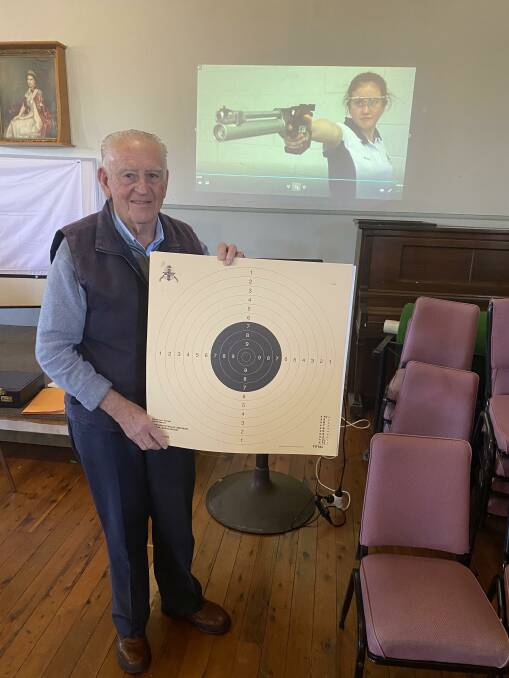 Allan Vorias holding the target used in the 25 and 50 metre shoots.