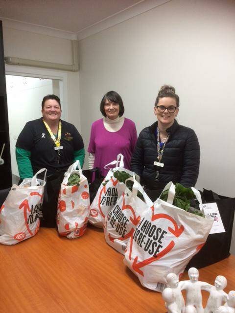 Maureen Knight (centre) presenting hampers to Bron Sainsbury and Katie Wilson at the Cowra Information and Neighbourhood Centre.
