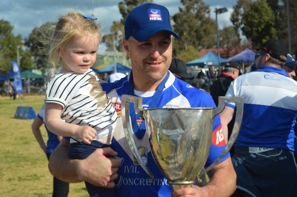 A SPECIAL MOMENT: Brent Dennis celebrates St Pat's first division premiership and his man-of-the-match gong with daughter Milla. Photo: MATT FINDLAY