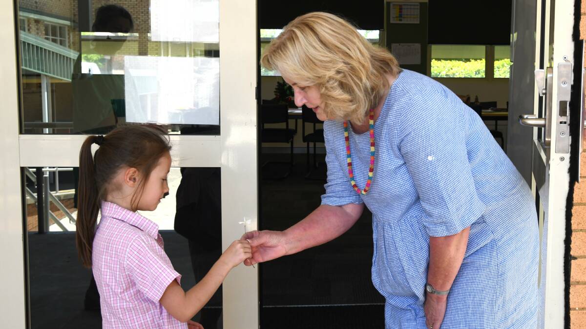 Claire Davis hands Gai Rosser a flower on her second last day of teaching. Picture by Carla Freedman