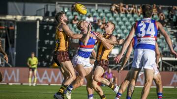 Western Bulldogs midfielder Adam Treloar gets crunched by Hawthorn players Conor Nash and James Worpel during a pre-season clash at UTAS Stadium. Pictures by Craig George 