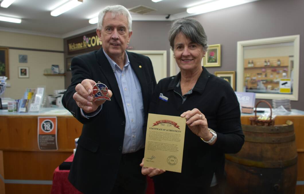 Chair of the Cowra Breakout 75th Anniversary Committee, Graham Apthorpe with Jenny Wright from the Cowra Visitors Information Centre showing off the medallions and certificates. 