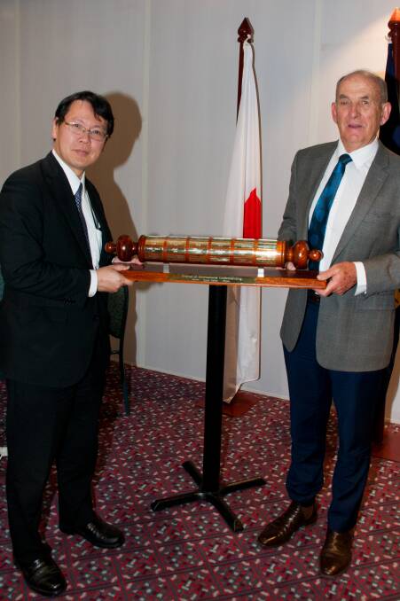 Minister Tokuro Furaya receives the baton from Mayor Bill West. 