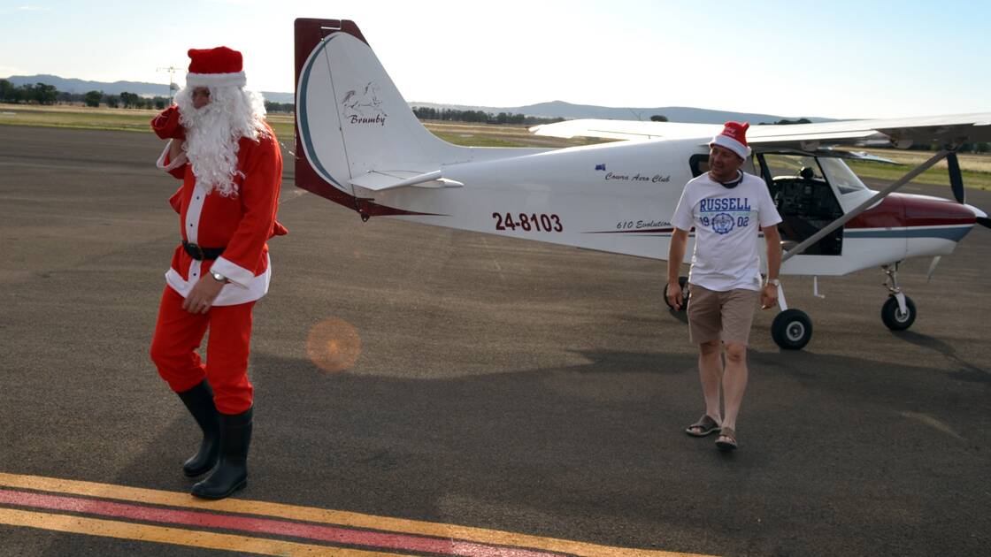 Santa arriving at Cowra Airport with Wayne Heilman. File photo. 