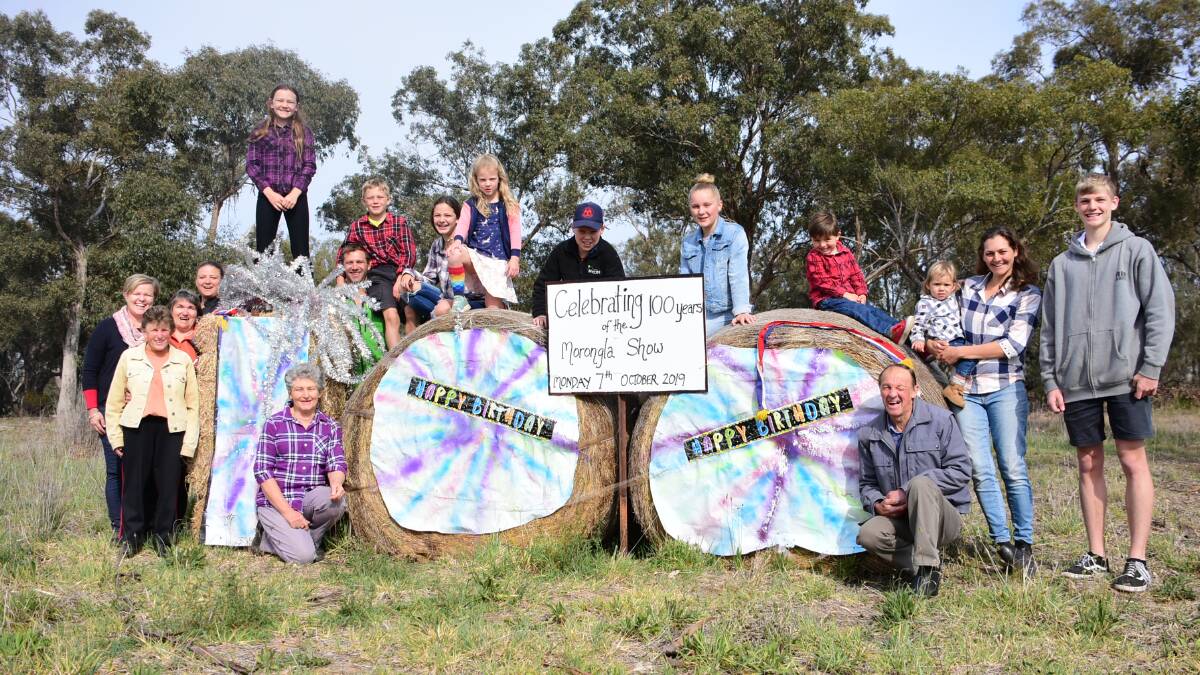 Committee members past and present, along with members of the Morongla community, stand near the 100 Hay Bale celebrating a century of the show. 
