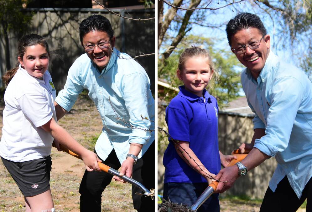 Isabella Lette (left) and Abby Bohanna with Middy Nakajima from IEC Oceania planting their trees on Thursday morning. 
