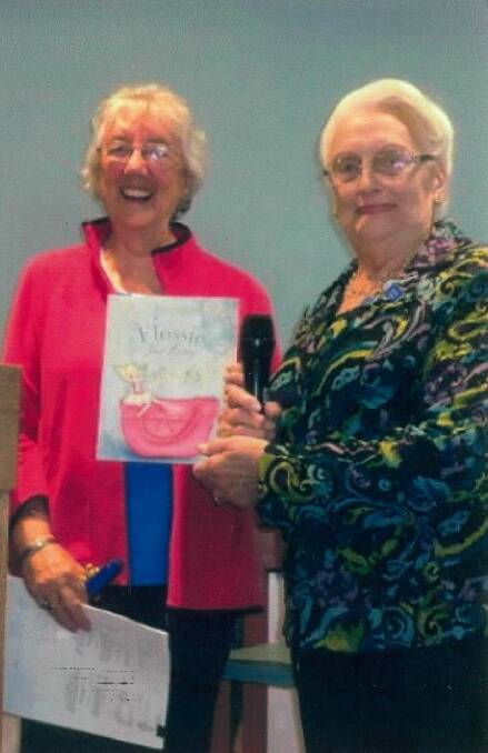 Josie Day and Nancy Watson showing one of her books, titled "Flossie the Fairy". 