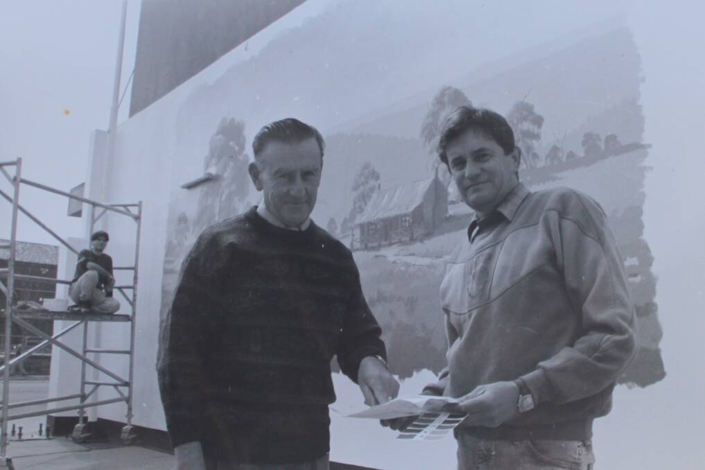 A photo which featured in the Cowra Guardian 25 years ago of building owner Allan Vorias and artist Glenn Morton working on the original mural. 