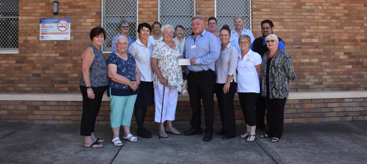 Cowra Hospital Auxiliary members, along with Cowra Hospital staff, receive a cheque from Coles Cowra last year. 