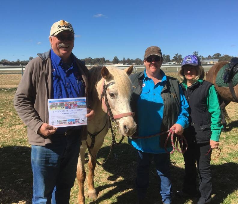RDA Cowra President David Hawkins holds the certificate of appreciation given to Allan Grey & Co for their sponsorship of RDA pony, Lucy. Lucy is held by RDA volunteer Julie-Ann Dromgold with coach Joy Webster. 