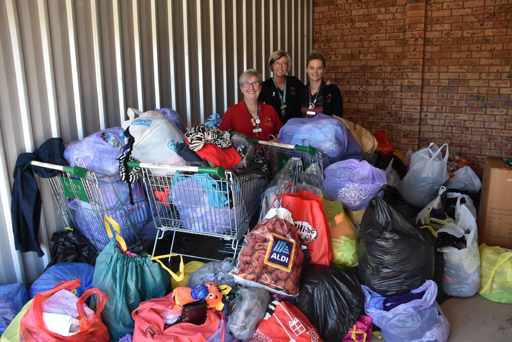 Marion Speechley, Fran Stead and Katie Wilson with almost a shed full of donated clothes for the Pop-Up Shop to raise funds for a domestic violence crisis centre. 