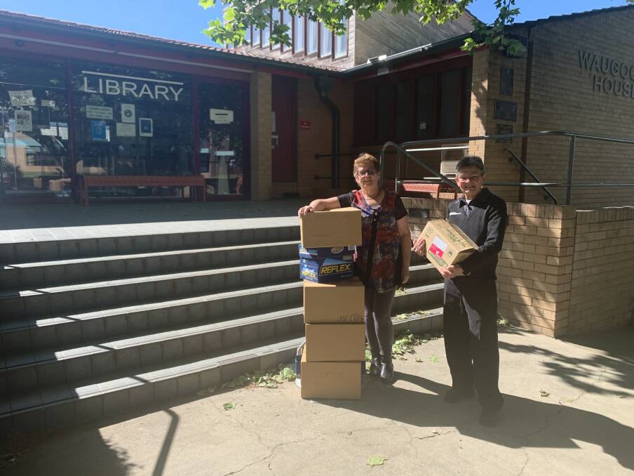 Robyn Guihot, who assists with Books for the Outback, with Cowra branch Librarian Terry Mills-Edward and the boxes of donations. 