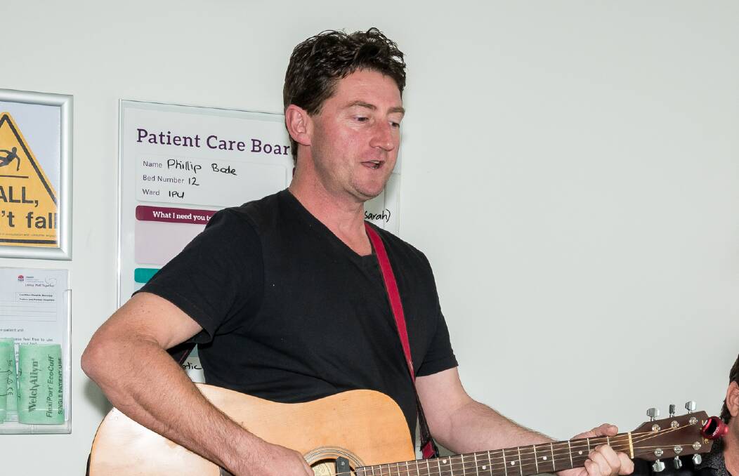 Blair Gough performs for a patient in hospital. Arts OutWest has provided training and support for Brian to become a musician.
