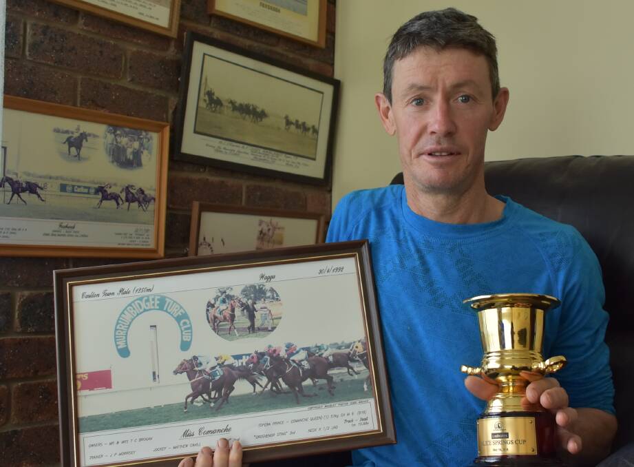 Mathew Cahill, pictured with the Alice Springs Cup he won in May this year and a framed picture of his win on Miss Comanche in the 1992 Wagga Town Plate.