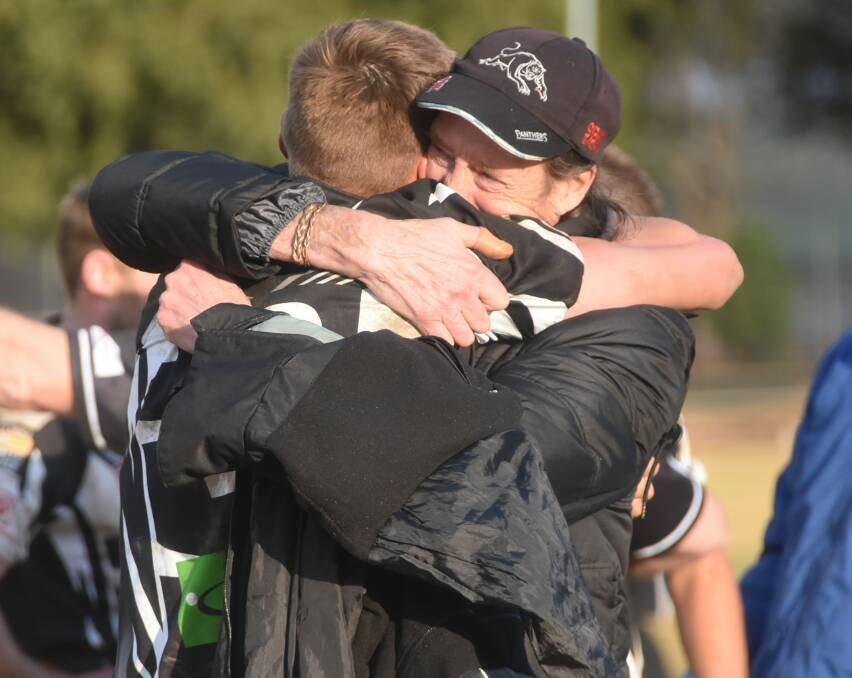 Cowra Magpies centre Bradyn Cassidy is embraced by his father.