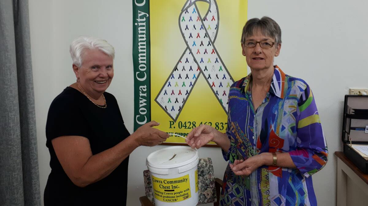 Committee President Joan Bailey handing over the donations to Marguerite Walmsley, Secretary of the Cowra Community Chest.