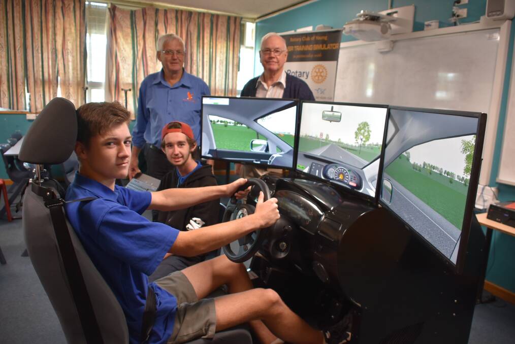 Students Daniel Barlow and Brock Dalton on the simulator with Ken Harris and Don Collins.