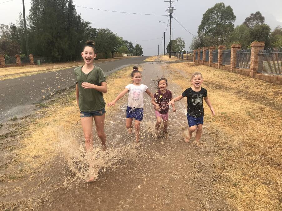Hannah Worth, Courtney Cherry, Stella Hyeronimus and Tyler Cherry run through a puddle following Friday's rain. Photo Nadia Cherry