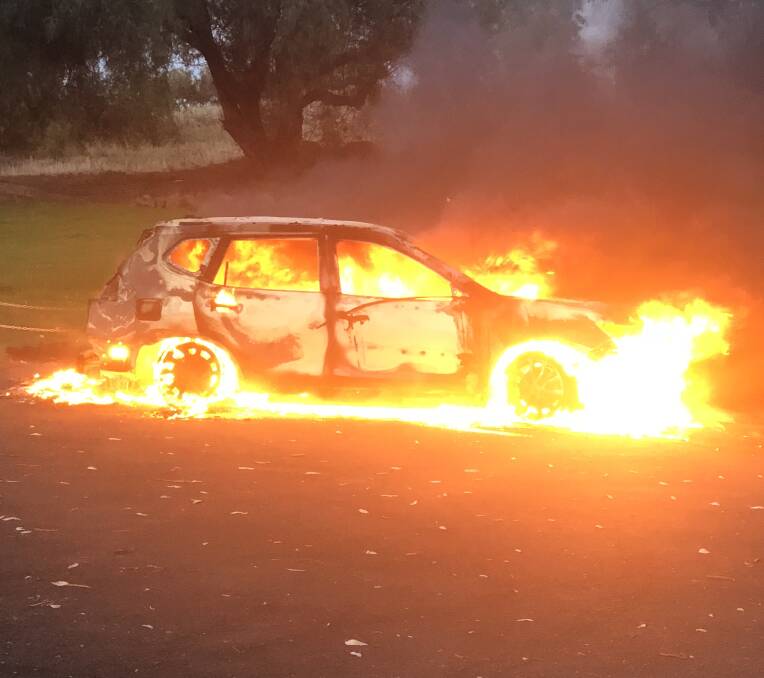The remains of a Nissan X-Trail alight in a Bellevue Hill car park early Friday morning. 