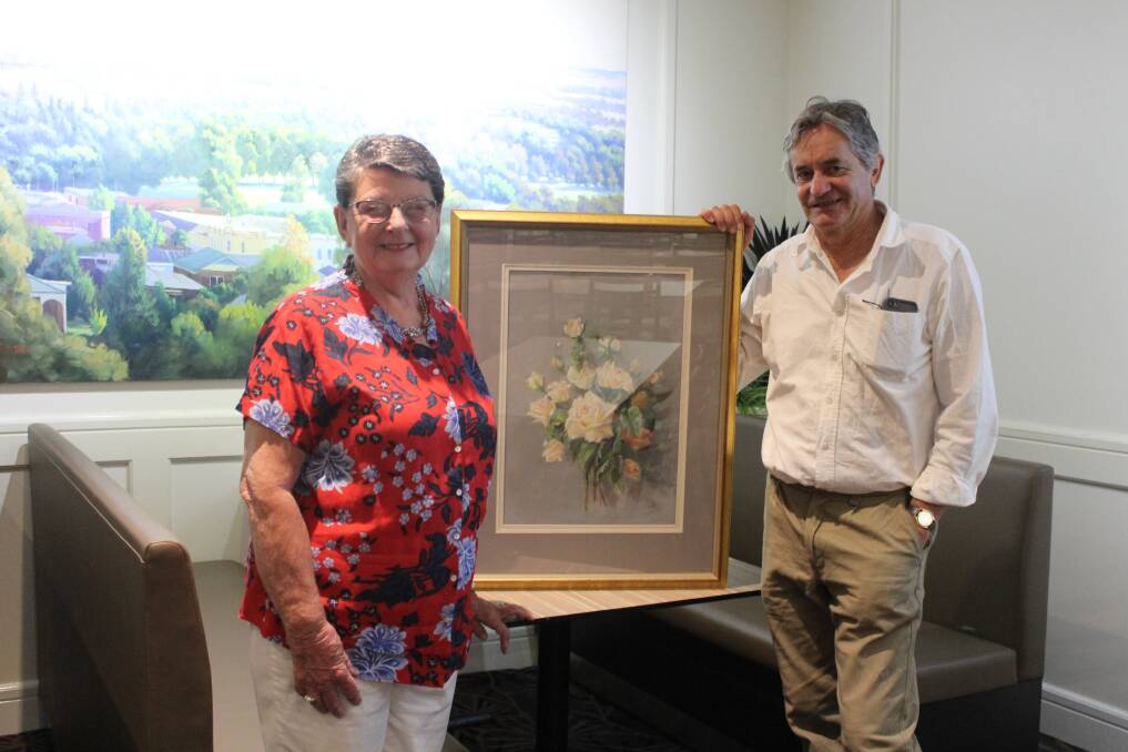 Barbara Newham and Glenn Morton with the painting donated by the Berry family for the Cancer Action Group's luncheon.