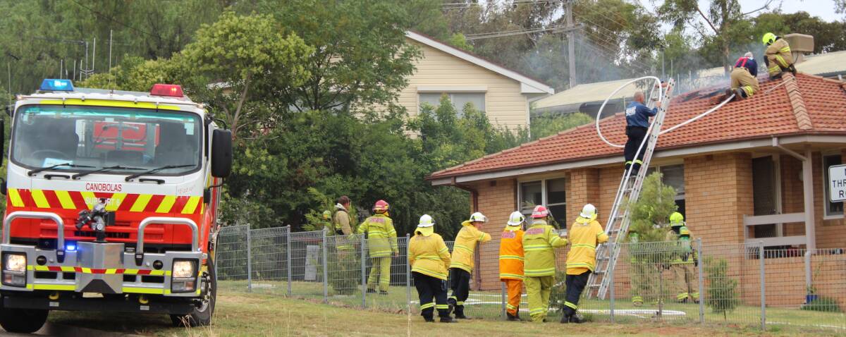 Cowra Fire and Rescue members accessing the fire through the roof of the home in Henderson Street on Tuesday.