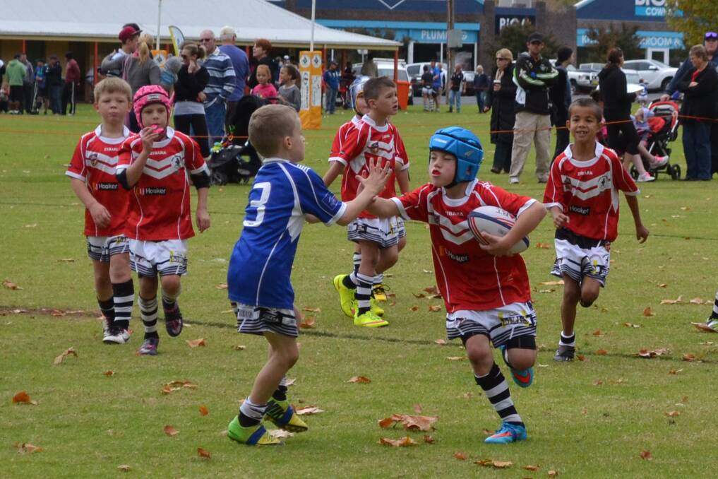 Aiden Green (centre) attempts to deflect a fend in the under 8s.